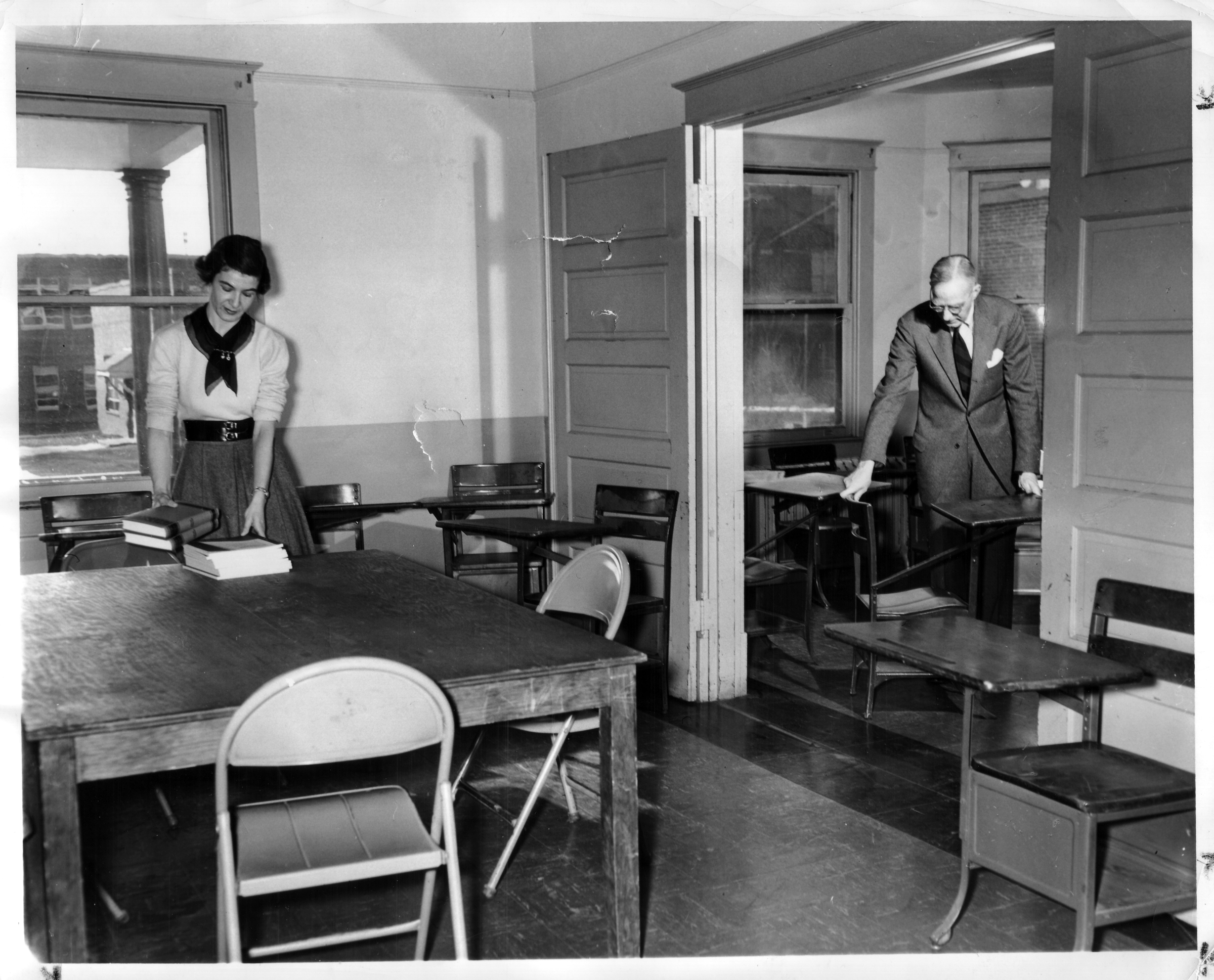 John Norville Gibson Finley and assistant set up desks in a classroom, Northern Virginia University Center, December 22, 1953.